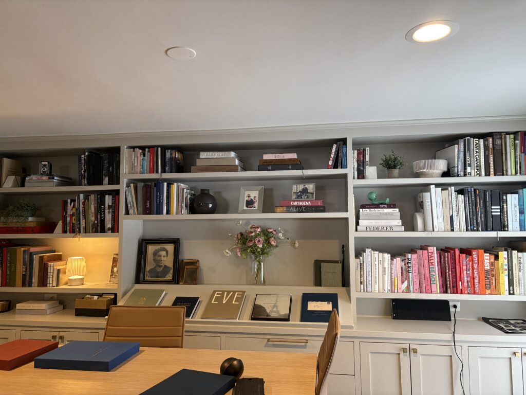 An after photo of the custom builtins styled with books neatly organized and special accesories peppered throughout